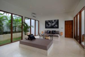 - un salon avec un canapé, des tables et des fenêtres dans l'établissement Modern and stylish 3 Bedroom Villa, à Ubud