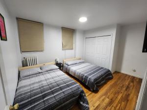 a bedroom with two beds and a white door at Spacious 3 bedroom apartment mins to NYC! in Union City