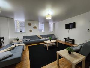 a living room with couches and tables and a tv at Spacious 3 bedroom apartment mins to NYC! in Union City