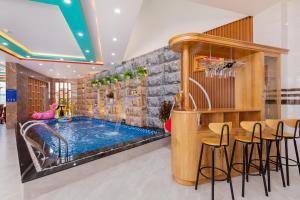 einen Pool in einem Zimmer mit Stühlen und einem Tisch in der Unterkunft Villas & Hotel 126 Vũng Tàu in Vũng Tàu