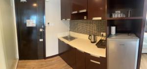 亞庇的住宿－Deluxe Twin Room AYS，厨房配有带水槽的柜台和冰箱。