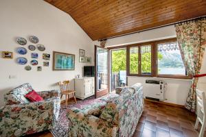 un soggiorno con divano e TV di Casa Paola al Lago - Happy Rentals a Ledro