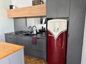 a kitchen with a red refrigerator in a kitchen at Cute annexe - close to Manly Marina in Brisbane