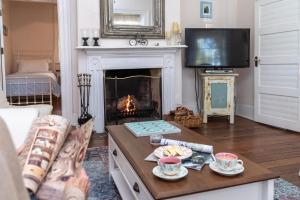 a living room with a fireplace and a tv at Surgeon's Cottage in Morpeth