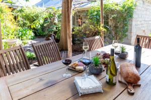 a wooden table with wine glasses and food on it at Surgeon's Cottage in Morpeth