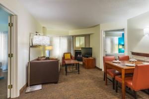 a living room with a couch and a dining room at Residence Inn Charlotte SouthPark in Charlotte