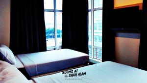 a hotel room with two beds and a window at Rooms at Hotel Shah Alam in Shah Alam