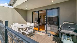 a balcony with a table and chairs and a grill at Island Holidayze in Cowes