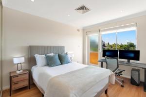 a bedroom with a bed and a desk with a computer at Randwick l 3 Bedroom Apartment + Parking in Sydney
