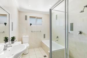 a bathroom with a toilet sink and a shower at Randwick l 3 Bedroom Apartment + Parking in Sydney