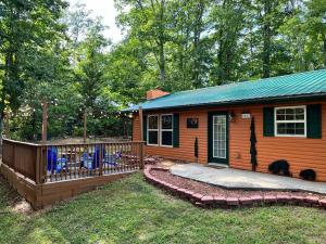 a log cabin with a deck and chairs in the yard at Paradise at the Smokies Cabin in Sevierville