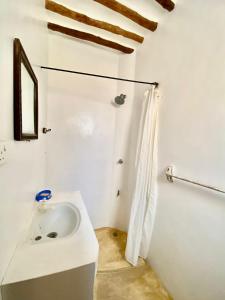 a white bathroom with a sink and a shower at Beautiful Mafriza Apartment in Lamu