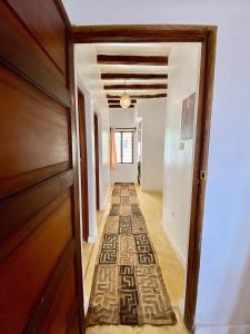 a hallway with a rug on the floor at Beautiful Mafriza Apartment in Lamu