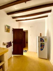una stanza vuota con frigorifero e porta di Beautiful Mafriza Apartment a Lamu