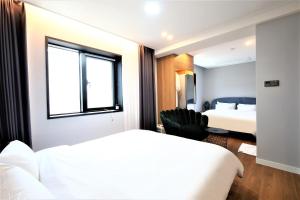 a hotel room with two beds and a window at De Lamour Hotel in Tongyeong