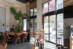 a restaurant with tables and chairs and large windows at COB HOTEL Asakusa in Tokyo