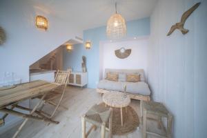 a living room with a couch and a table at Appart'Hôtel & Spa "Les Voiles" Le Houat in Carnac