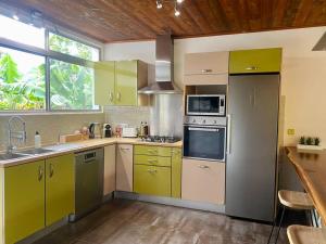 a kitchen with yellow and green cabinets and a sink at Villa Hoama Lodge Moorea in Teavaro