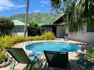 a swimming pool with two lawn chairs next to a house at Villa Hoama Lodge Moorea in Teavaro