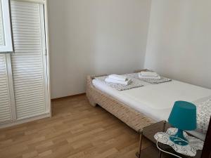 1 dormitorio pequeño con 1 cama y 1 silla en Apartment Zmisa, en Stara Novalja