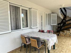 a dining room with a table and chairs and windows at Apartment Zmisa in Stara Novalja
