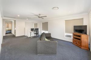 uma sala de estar com um sofá e uma televisão de ecrã plano em Large house 7 mins from Airport em Brisbane