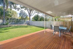 a patio with a table and chairs on a deck at Large house 7 mins from Airport in Brisbane