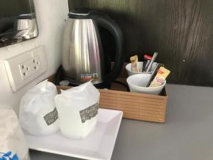 a counter with two white bowls and a coffee pot at PP Midnight Hotel in Phi Phi Don