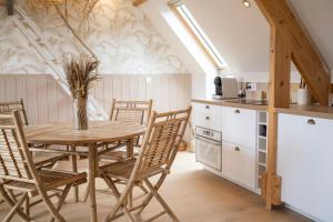 cocina y comedor con mesa de madera y sillas en Les Voiles - Appart'hotel "Le Molène", en Carnac