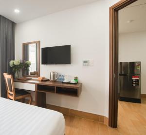 a hotel room with a desk and a television at GoldCoast Hotel Nha Trang in Nha Trang