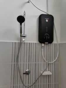 a shower in a bathroom with a phone on the wall at DKAMAR Homestay At Desaru, IKEA Concept, Wifi, 3 Airconds, Nearby Desaru Beach in Bandar Penawar