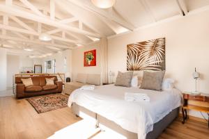 1 dormitorio con 1 cama grande y 1 sofá en Vlei Cove, en Ciudad del Cabo