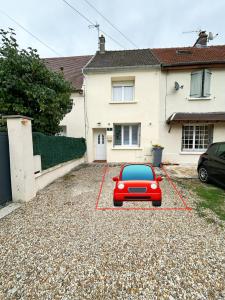 un coche rojo estacionado frente a una casa en La Maison de Mickey - Disneyland Paris, en Bailly-Romainvilliers