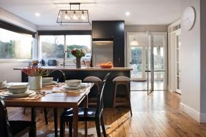 a kitchen with a wooden table with chairs and a dining room at The Arlow House in Daylesford