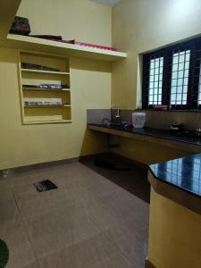 ein leeres Zimmer mit einem Schreibtisch und einem Fenster in der Unterkunft Pebbles in Kozhikode