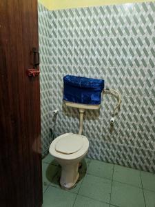 ein Bad mit einem WC und einem blauen Beutel darauf in der Unterkunft Pebbles in Kozhikode