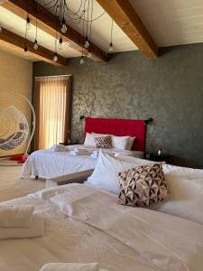 a bedroom with two beds with white sheets and a red headboard at Sea Holly Gozo in Nadur
