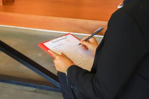 a person writing in a notebook with a pen at Grand Yard La Residence in Siem Reap