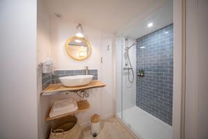 a bathroom with a sink and a shower at Les Voiles - Appart'hotel "Le Sein" in Carnac