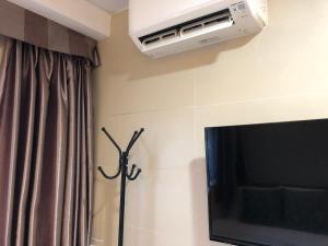 a living room with a television and a air conditioner at 香港星星旅馆 b&b in Hong Kong