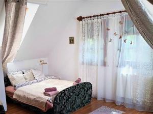 a bedroom with a bed and a window with curtains at Vendégház a Csabay Kúriához in Lakitelek
