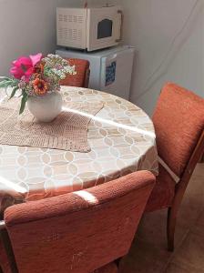 a table with a vase of flowers on top of it at Vendégház a Csabay Kúriához in Lakitelek