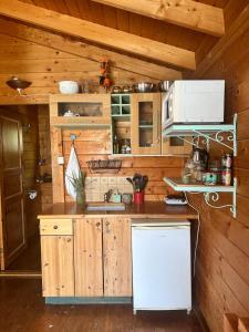 een keuken met houten kasten en een witte koelkast bij הבלוט - בקתה אינטימית בצל אלון in Abirim