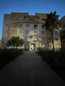 ein großes Gebäude mit einer Palme davor in der Unterkunft Appartement saidia 2 chambres in Saidia 