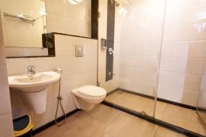 a bathroom with a toilet and a sink at Hotel Prestige, Mangalore in Mangalore +33 photos