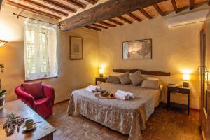 ein Schlafzimmer mit einem großen Bett und einem roten Stuhl in der Unterkunft Agriturismo Villa Alari in Cetona