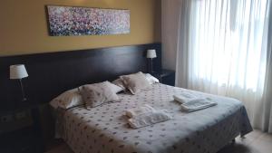 a bedroom with a bed with pillows on it at ALBERTI APARTAMENTS in Campana