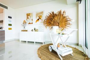 a white room with a white cart with a plant at Voyage 5 Star Al Hadeel Sunset Sea View in Abu Dhabi