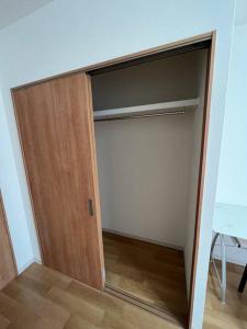 a closet with a wooden door in a room at Roxy inn in Oita
