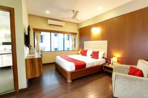 a hotel room with a bed and a couch at Hotel Prestige, Mangalore in Mangalore